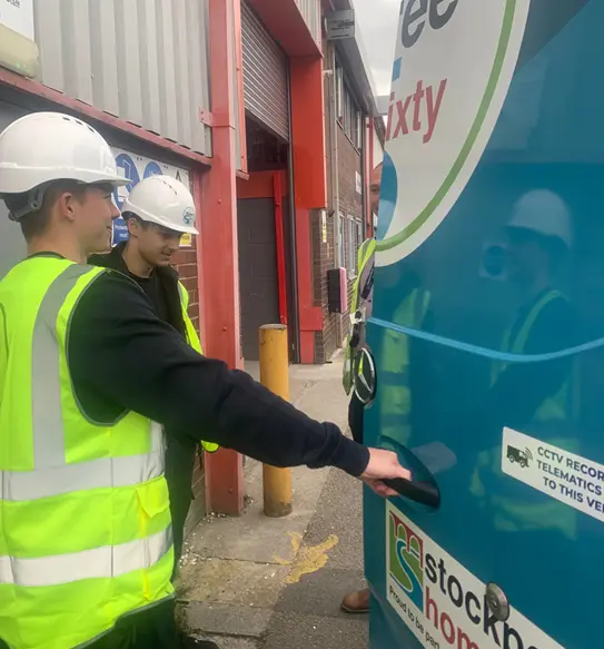 two men wearing hi-viz and helmets opening a three sixty van