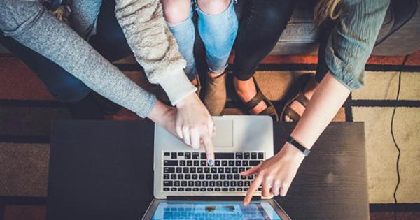 multiple hands pointing to a laptop screen 