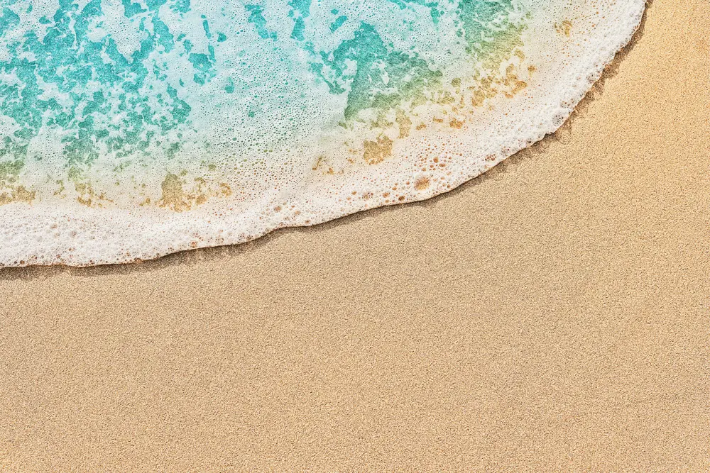 Top view of beach water meeting sand