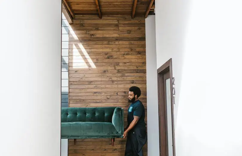 Side shot of men moving a couch into a home