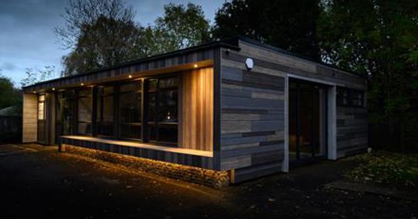 night time view of wooden building with warm lights at the side 