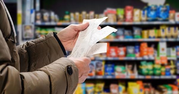 A woman holding a receipt in a supermarket