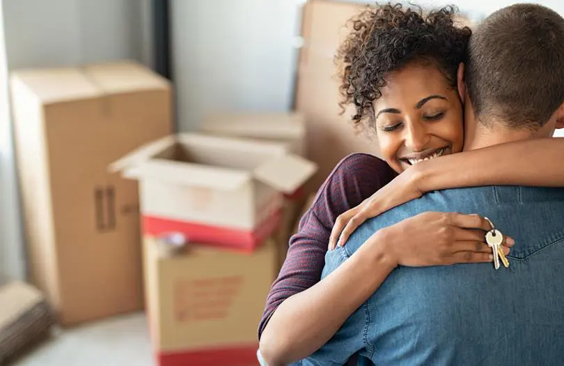 Happy couple in new home with boxes in the background