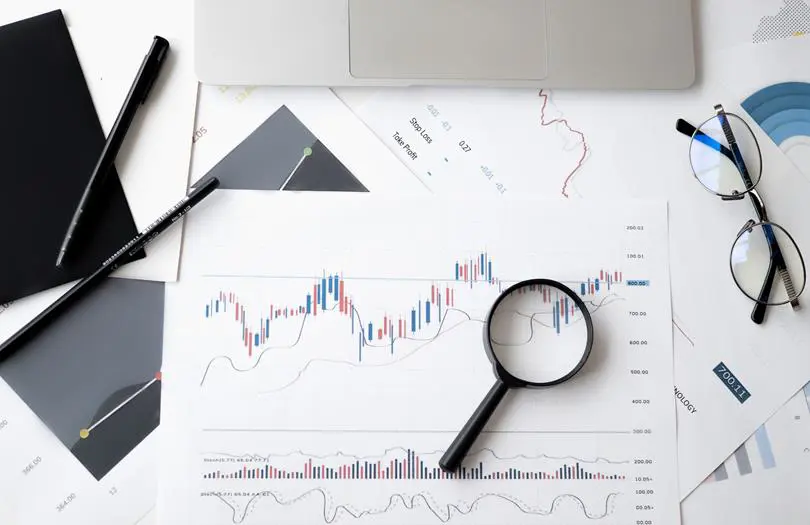 graphs on paper with magnifying glass 