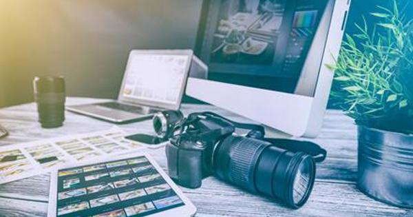 camera and tablet on desk with monitor