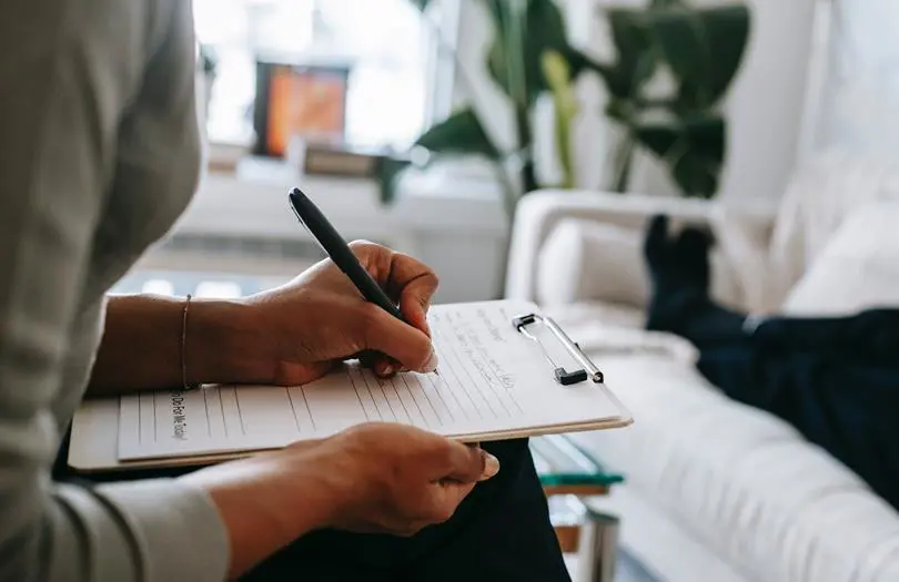 woman writing on a notepad