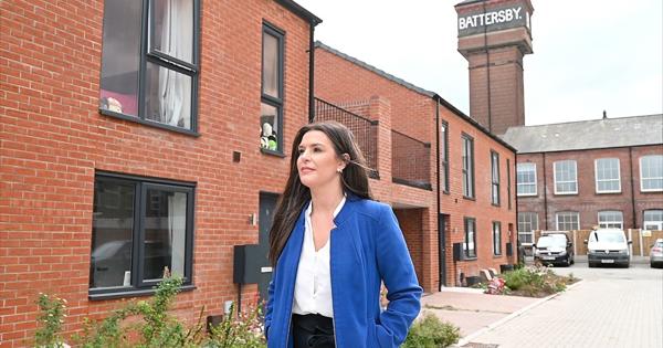 Female Walking In Front Of New Build Homes