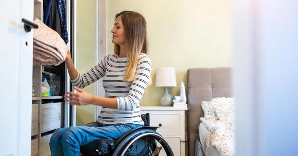 Woman in wheelchair getting something out of a cupboard 