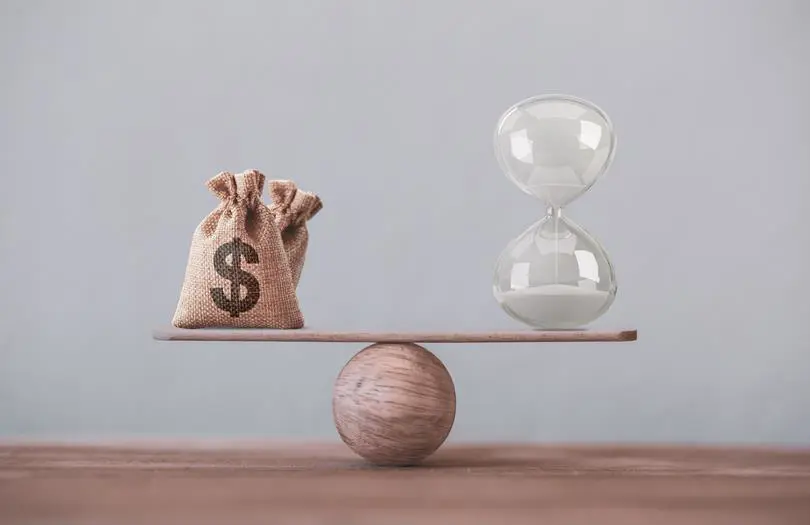 money balancing on ball with sand timer