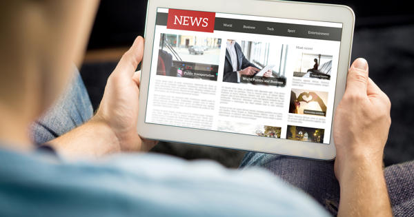 Man with tablet looking at news