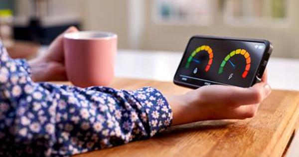 A woman with a mug holding an smart meter
