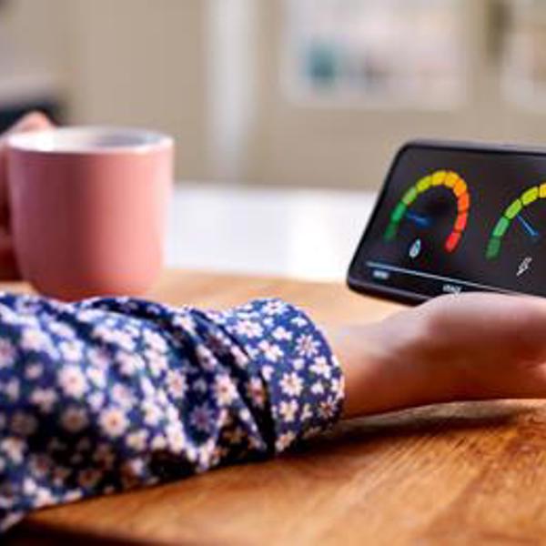A woman with a mug holding an smart meter