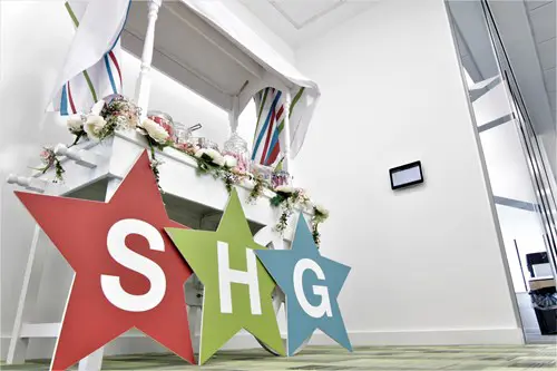 SHG star letters on wooden boards against a white sweet stand