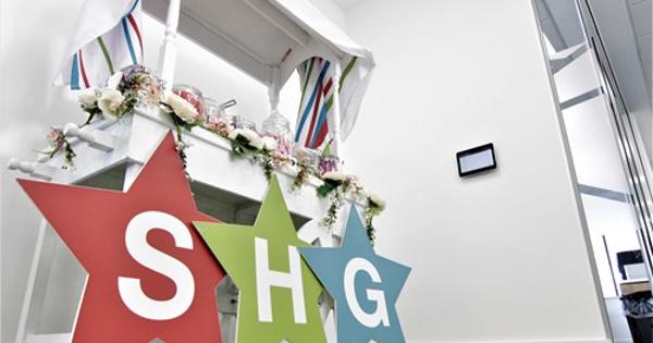 SHG star letters on wooden boards against a white sweet stand