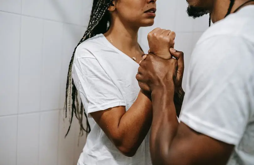 man holding up woman against a wall