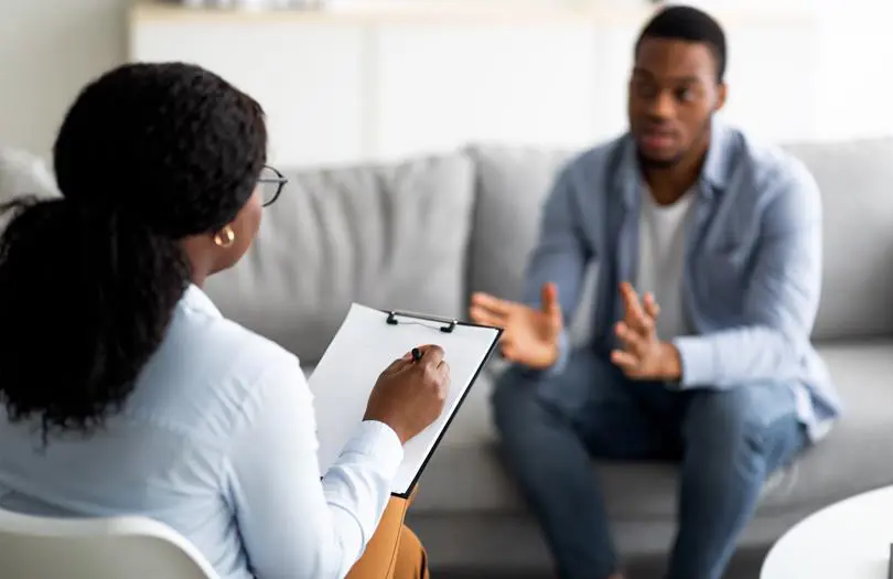 Female With Clipboard Talking To Man