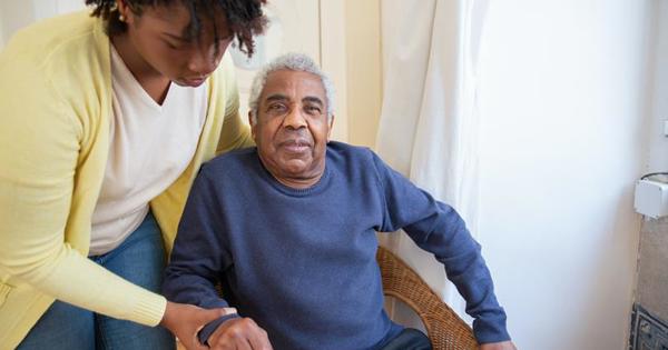 woman helping older man out of chair