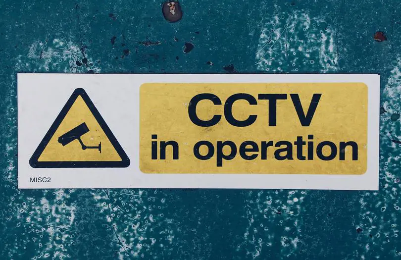 CCTv in operation sign on blue wall