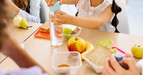 Children together at a desk having a school meal 