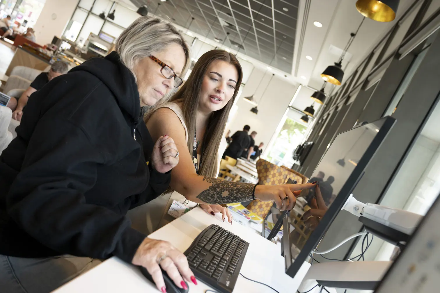 Female Helping Another Female On A Computer
