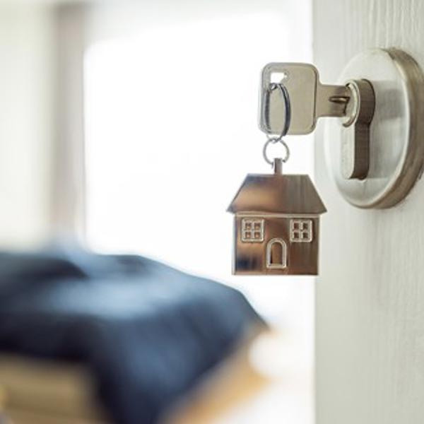 Home keychain on a key inside a keyhole