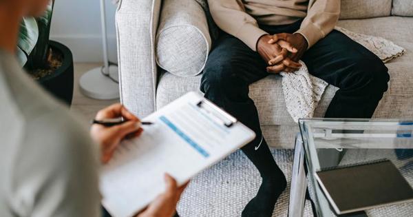Woman writing on a notepad with man on sofa