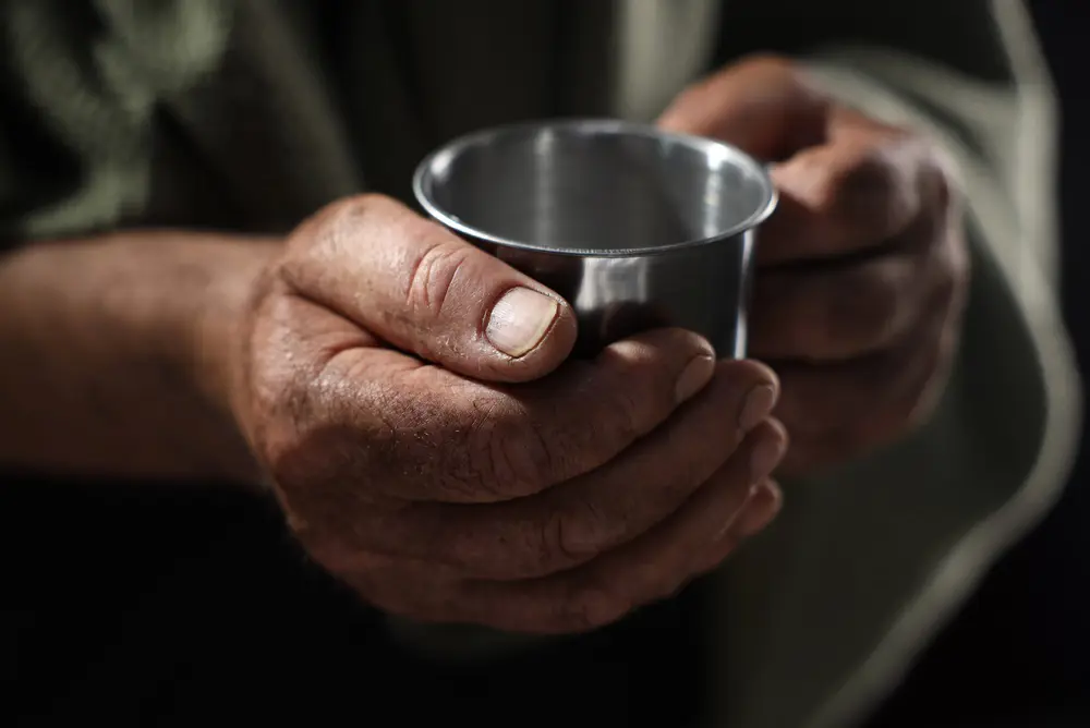 close up hands holding a metal mug 