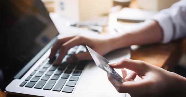 hand holding credit card and typing on laptop