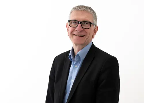 Steve Partridge headshot wearing a shirt and suit jacket