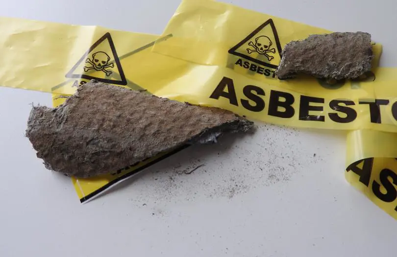 Yellow tape with the word Asbestos on it covering some walling