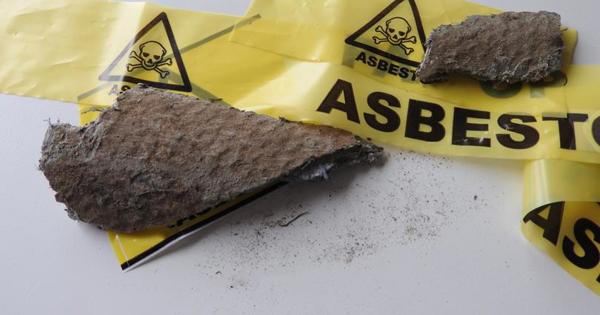 Yellow tape with the word Asbestos on it covering some walling