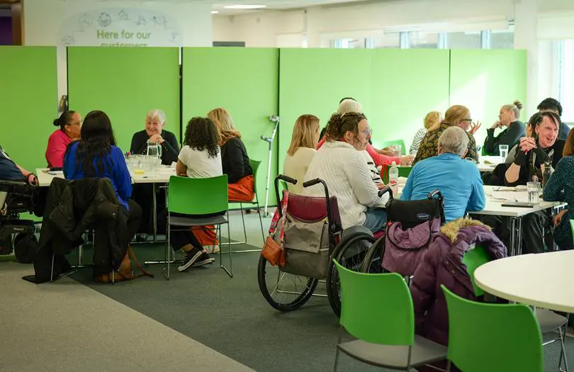 group of customers in green seats and backdrop