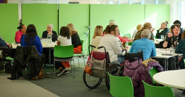 group of customers in green seats and backdrop