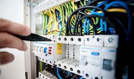 fingers pointing to a fuse box
