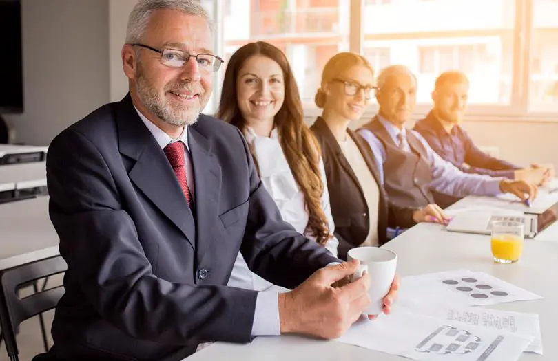 Smiling Senior Manager With His Colleagues Sitting Together Meeting