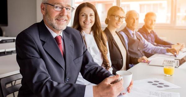 Smiling Senior Manager With His Colleagues Sitting Together Meeting
