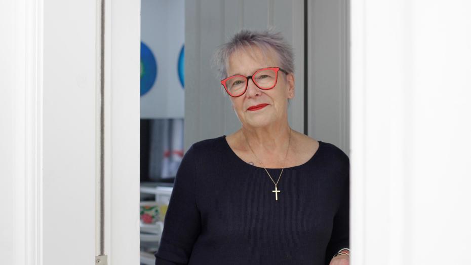 Older woman with red glasses at door 
