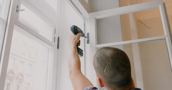 man with drill repairing a window