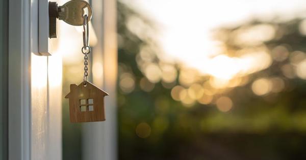 key with wooden house keychain in a door 