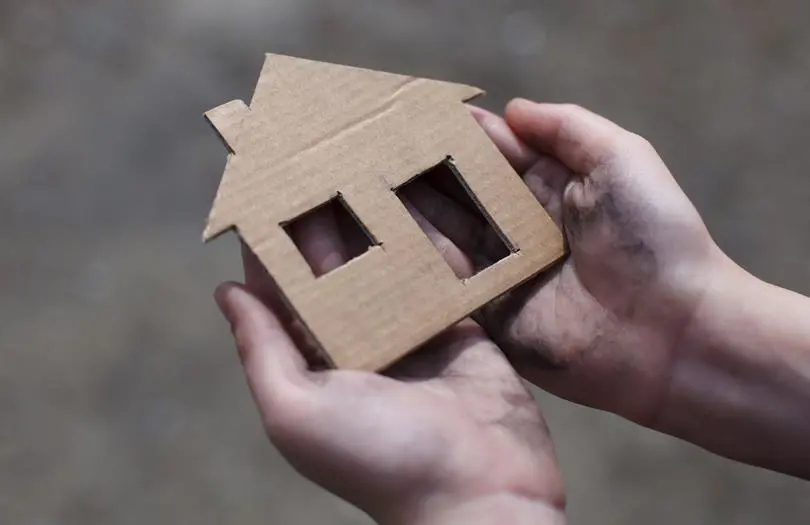 Hands Holding Cardboard House
