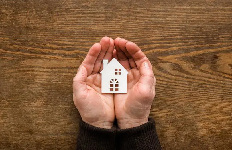 hands holding a small house icon