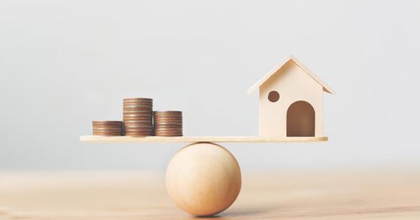 coins balanced on a ball against a wooden house