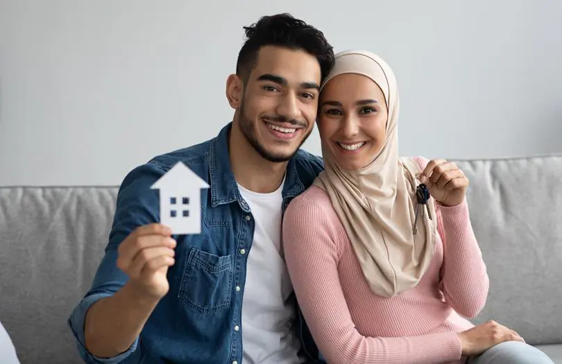 Couple On Sofa With Keys To New House
