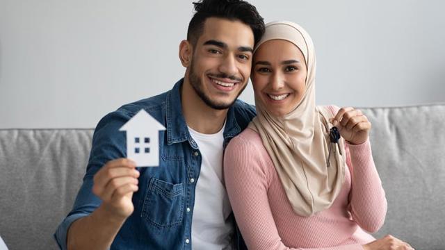 Couple On Sofa With Keys To New House