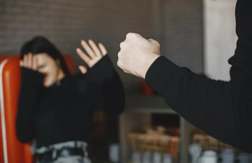 woman shielding herself against a fist