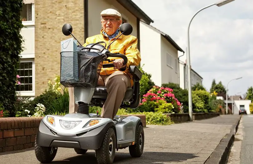An older man on a Mobility Scooter on a street