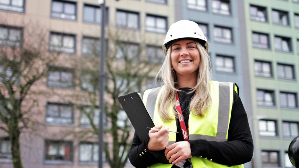 Woman with safety gear in front of high rise