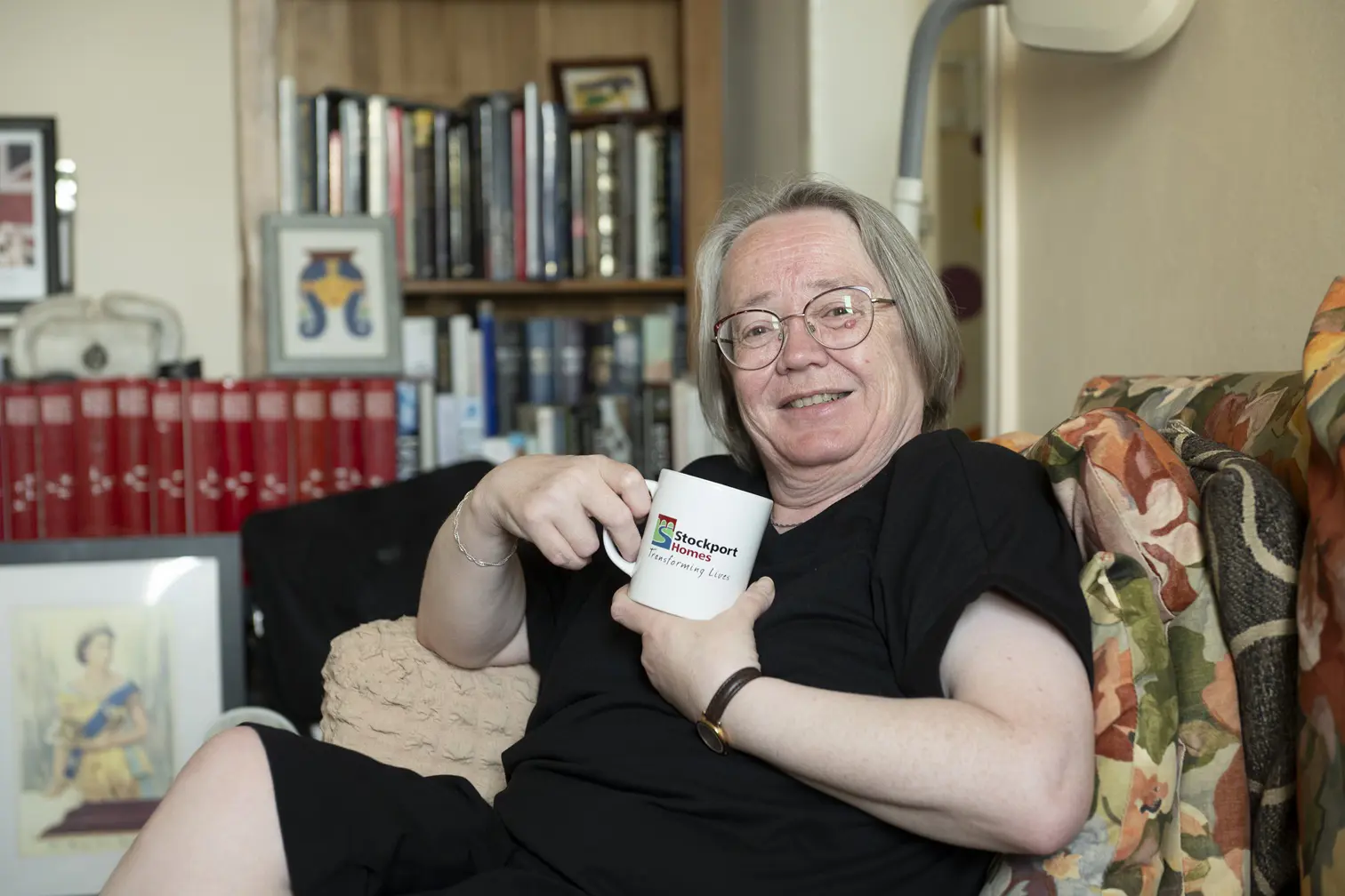 Female Having Cup Of Tea In Living Room