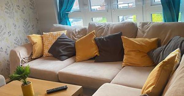 A sofa with yellow and black pillows inside a house