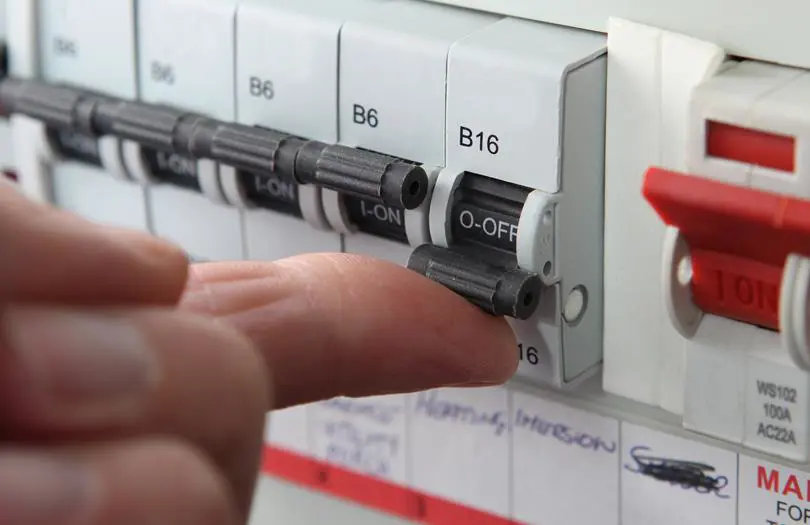 Close up of a hand pushing a switch on a fuse box